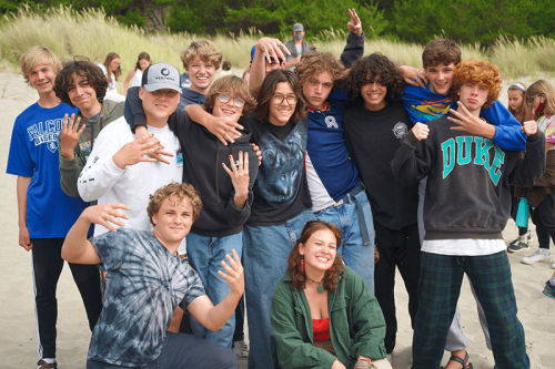 A group photo of teenagers on the beach at camp