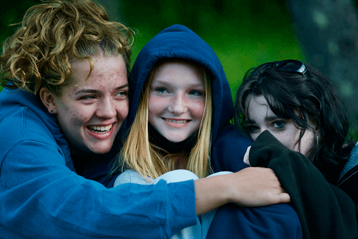 Teenagers talking and smiling at camp