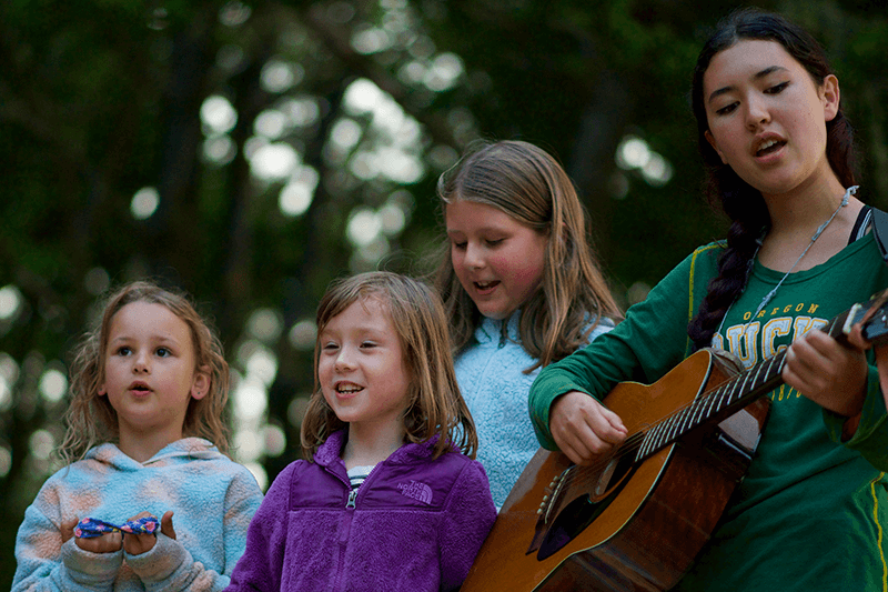 Young campers playing guitar and singing