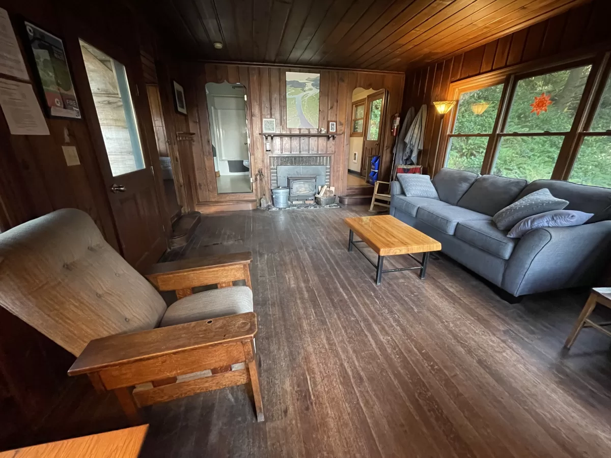 Living room with chair, coffee table, and couch. Fireplace on back wall.