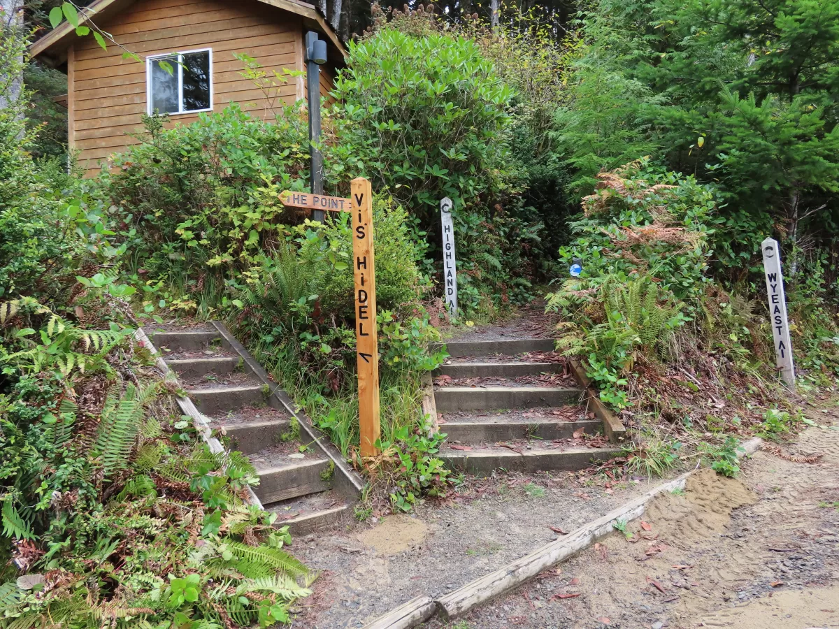 two sets of wooden stairs leading in two directions, sign posts directing which way