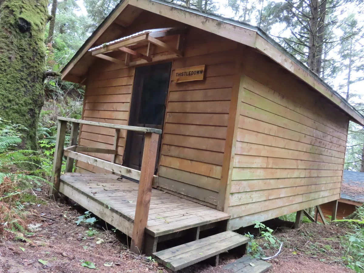 Exterior of wooden cabin, with small wooden deck