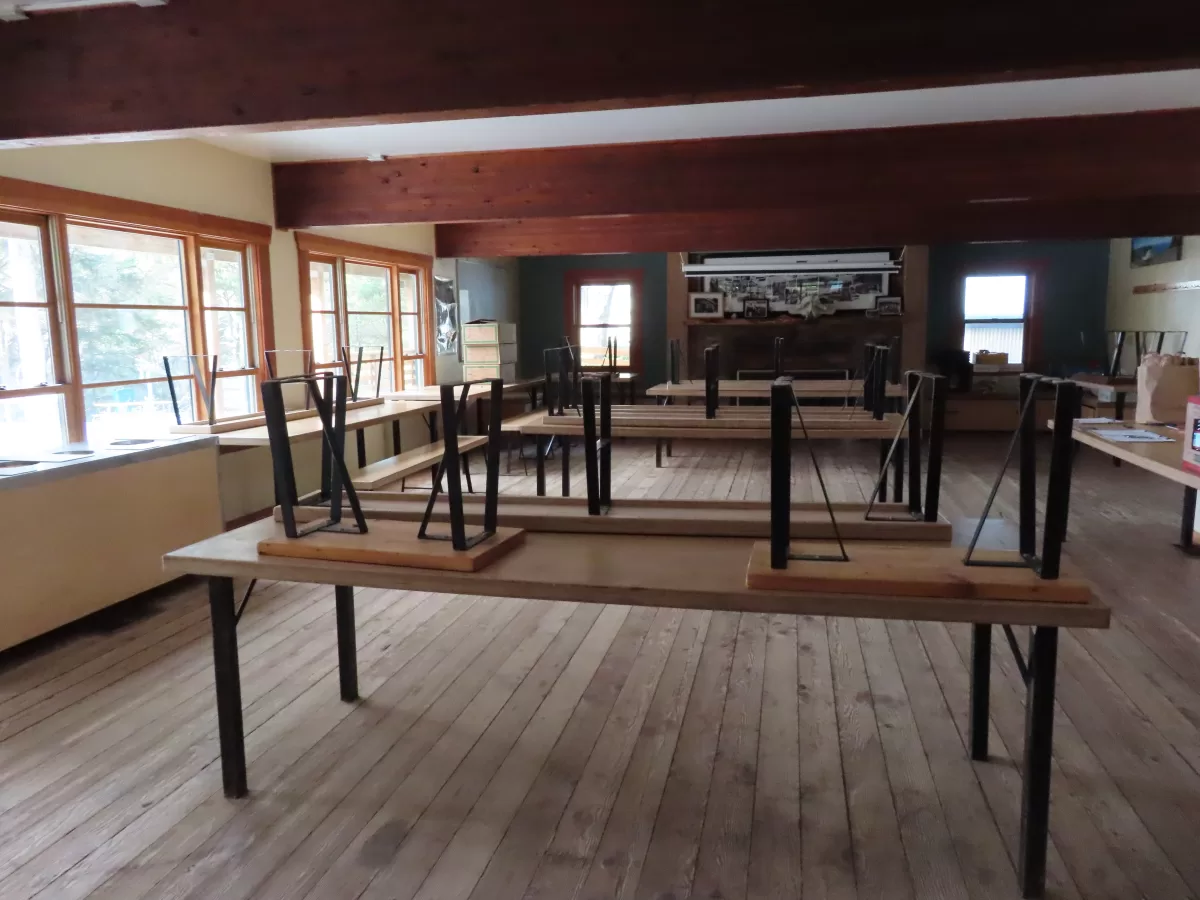 Interior lodge with three tables and two benches per table.