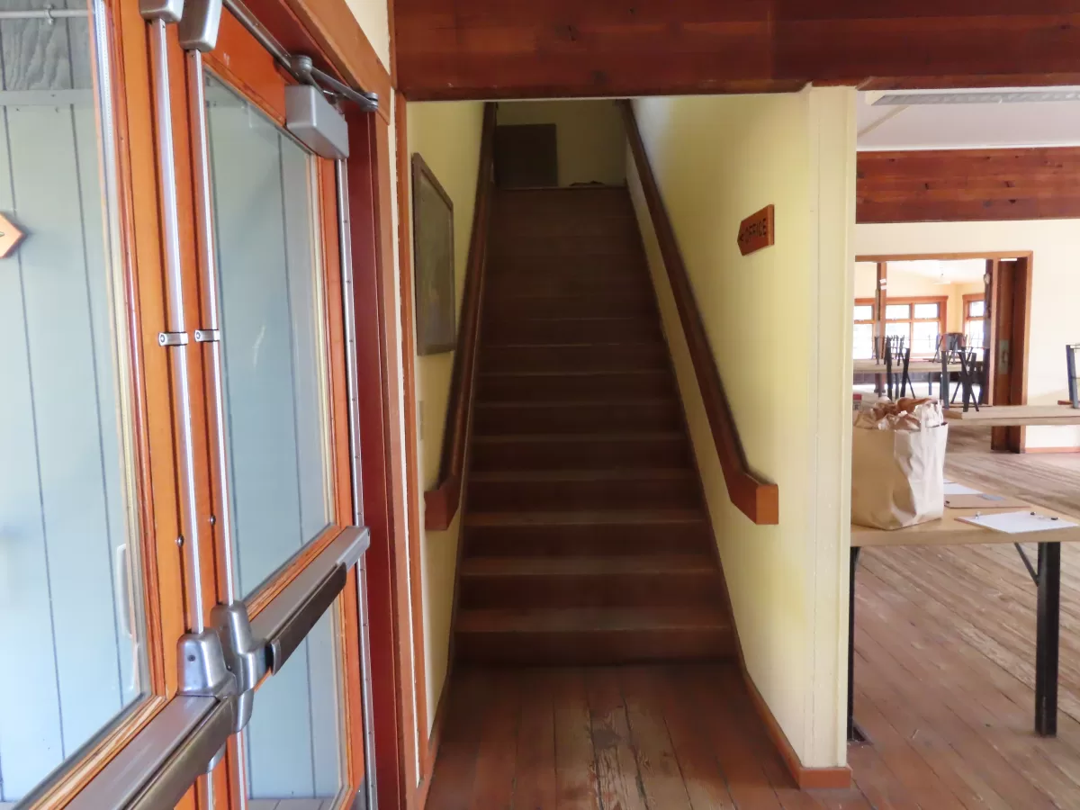 Stair case leading up to offices. Wooden railings on either side.