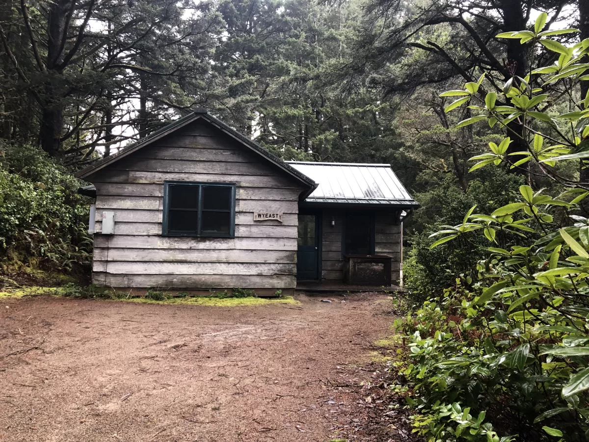 Wooden cabin with small porch. Cabin name "Wyeast." Open dirt area in front.