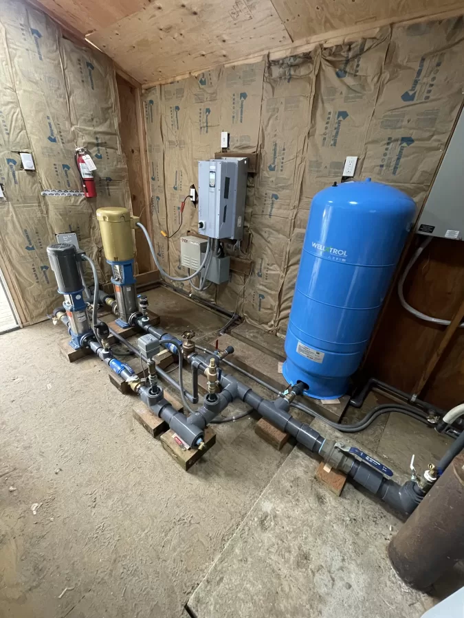 multiple water pipes connecting to pumps and larger tanks. 