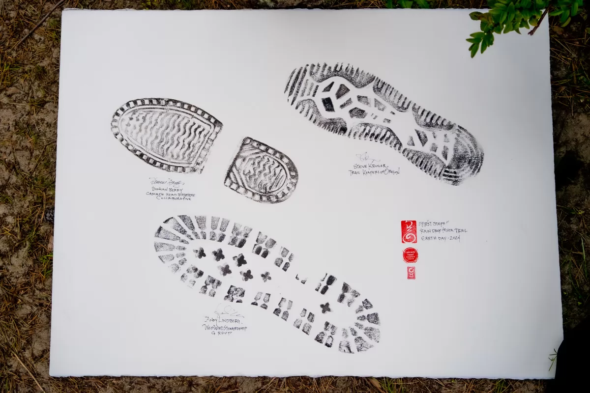 paper with three boot prints commemorating raindrop to sea trail