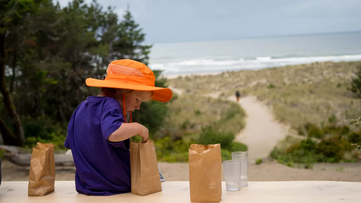 child examines contents of brown paper bag