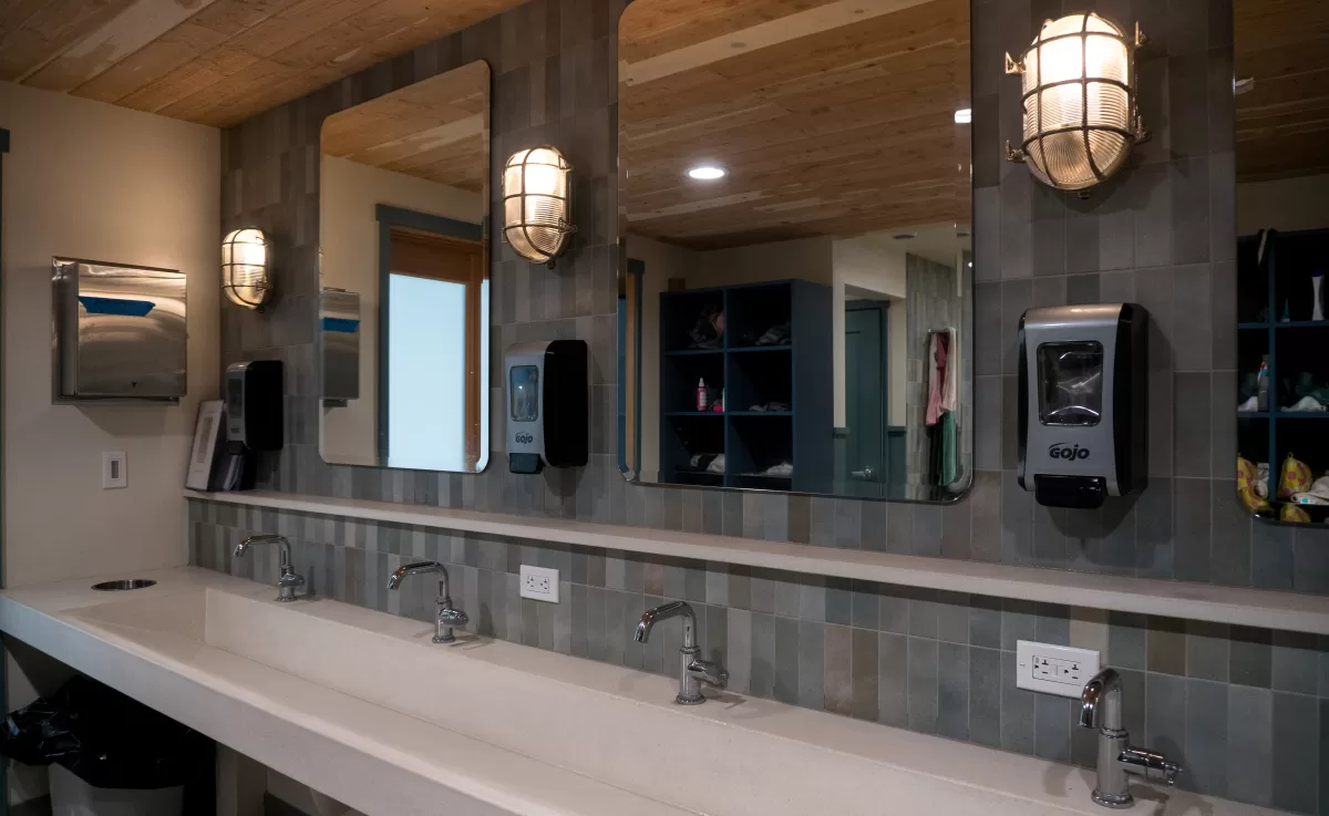 bathroom sink area with mirrors and troth sink.