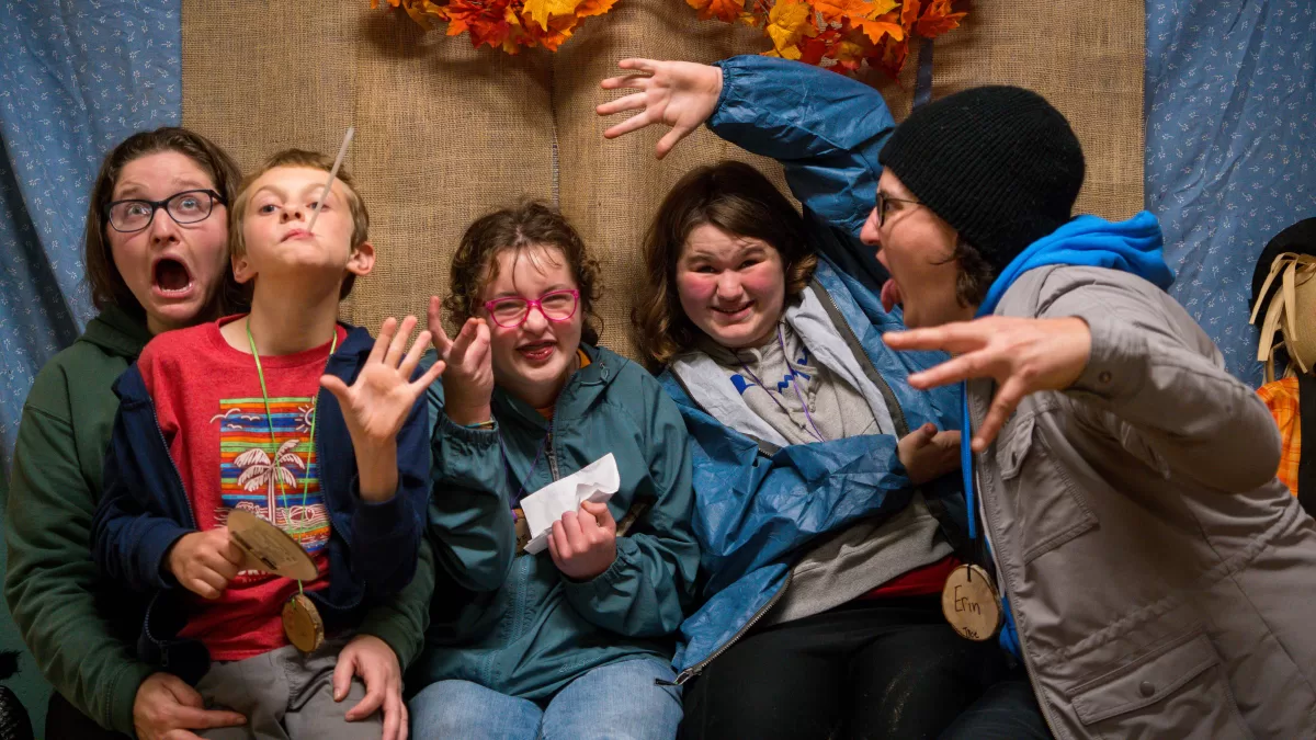 A family of five poses for a silly photo 